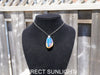 Handcrafted Dominican amber pendant with glowing blue and golden highlights, featuring unique gemstone details and artisan craftsmanship