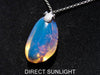 Handcrafted Dominican amber pendant with glowing blue and golden highlights, featuring unique gemstone details and artisan craftsmanship