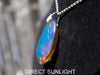 Handcrafted Dominican amber pendant with glowing blue and golden highlights, featuring unique gemstone details and artisan craftsmanship