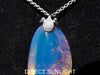 Handcrafted Dominican amber pendant with glowing blue and golden highlights, featuring unique gemstone details and artisan craftsmanship