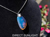 Handcrafted Dominican amber pendant with glowing blue and golden highlights, featuring unique gemstone details and artisan craftsmanship