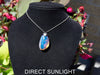 Handcrafted Dominican amber pendant with glowing blue and golden highlights, featuring unique gemstone details and artisan craftsmanship