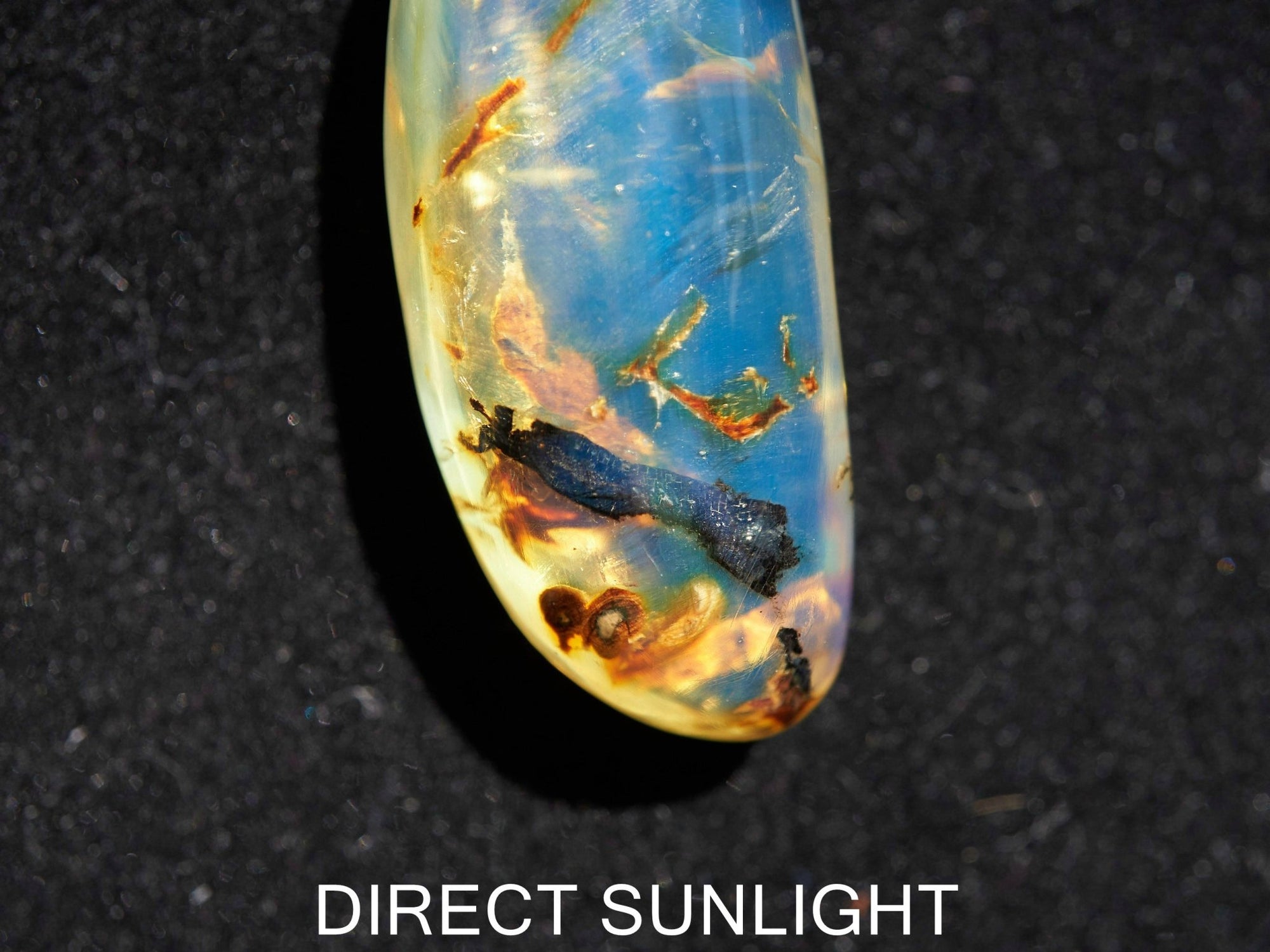 Close-up of a rare Dominican blue amber cabochon showing its unique patterns and inclusions