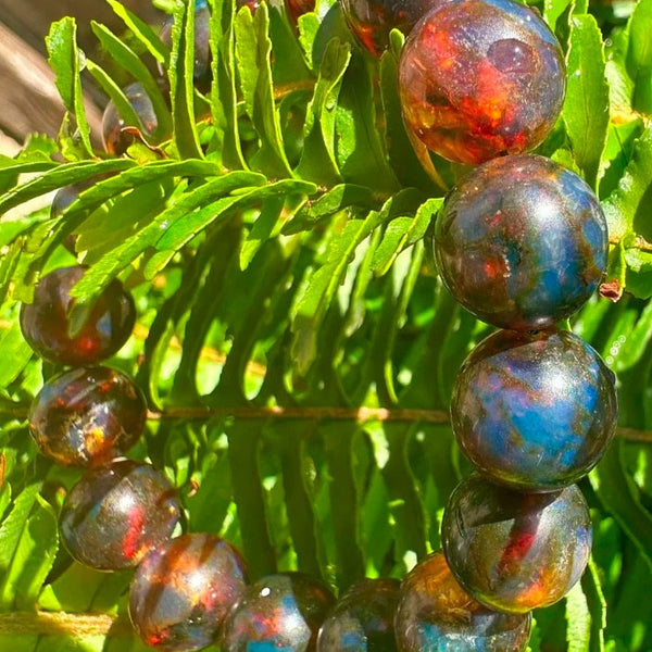 Multicolored beaded bracelet on a green leafy background