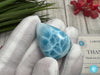 Close-up of a polished natural Larimar cabochon in a smooth teardrop shape, showcasing vibrant oceanic blue hues with subtle white marbling, perfect for jewelry making or as a collectible gemstone