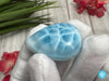 Close-up of a polished natural Larimar cabochon in a smooth teardrop shape, showcasing vibrant oceanic blue hues with subtle white marbling, perfect for jewelry making or as a collectible gemstone