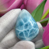 Close-up of a polished natural Larimar cabochon in a smooth teardrop shape, showcasing vibrant oceanic blue hues with subtle white marbling, perfect for jewelry making or as a collectible gemstone