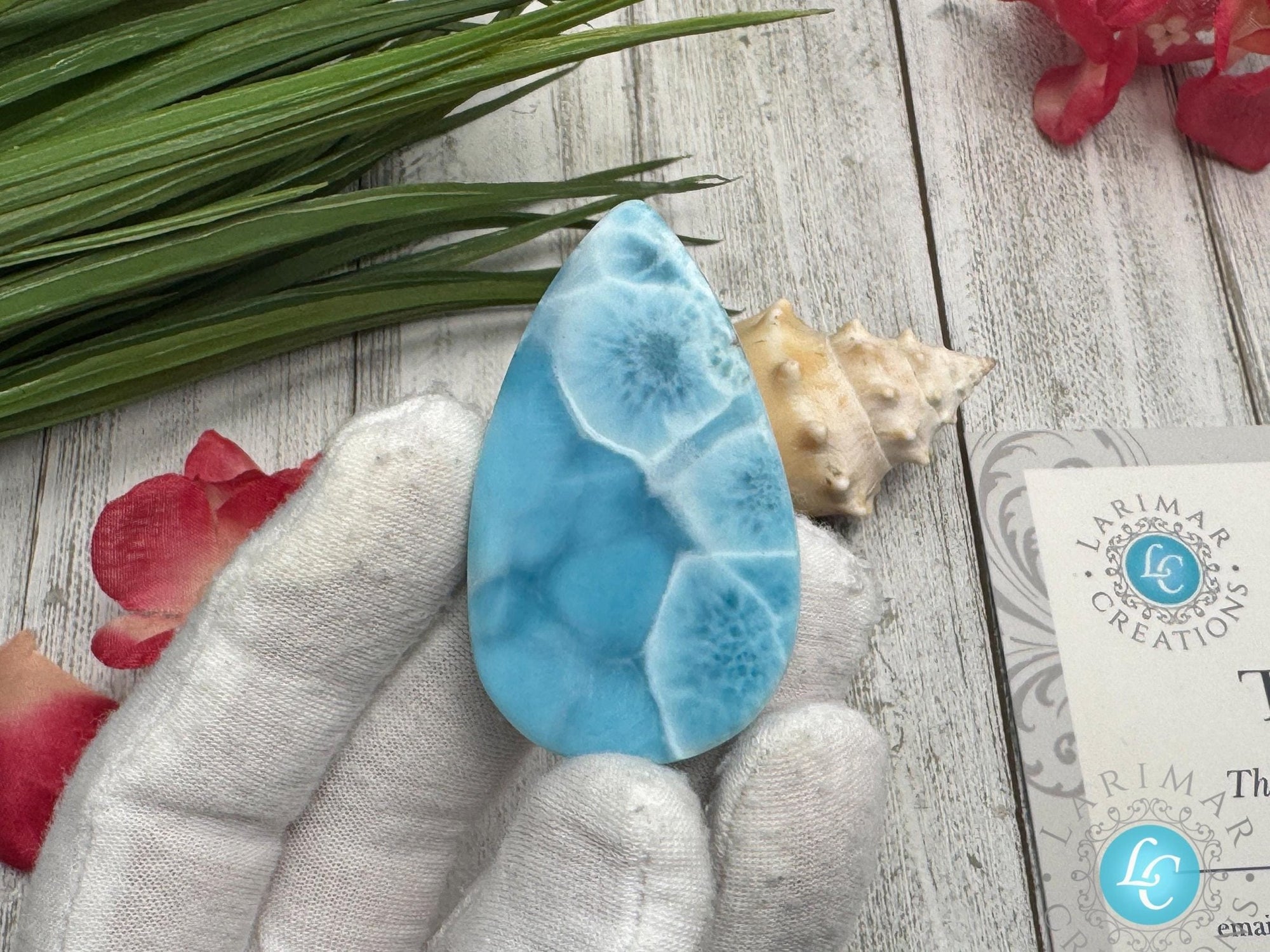 Close-up of a high-quality Larimar cabochon with vibrant Caribbean blue hues and natural white patterns, polished