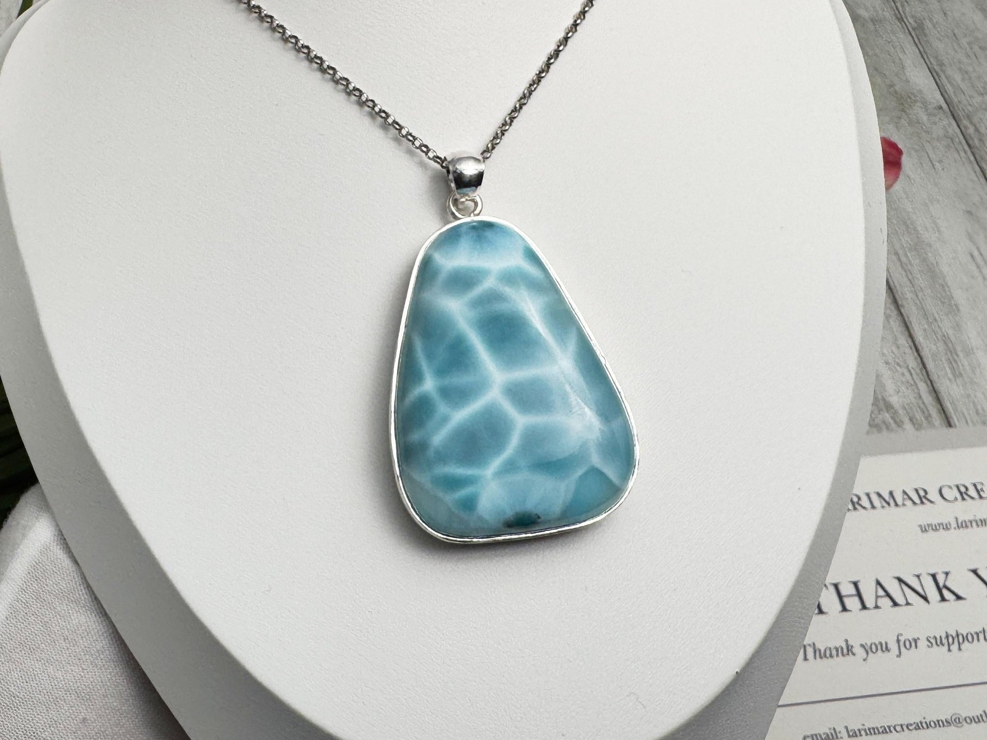 Unique Larimar jewelry piece with a sterling silver chain, beautifully presented with a branded thank-you card and tropical