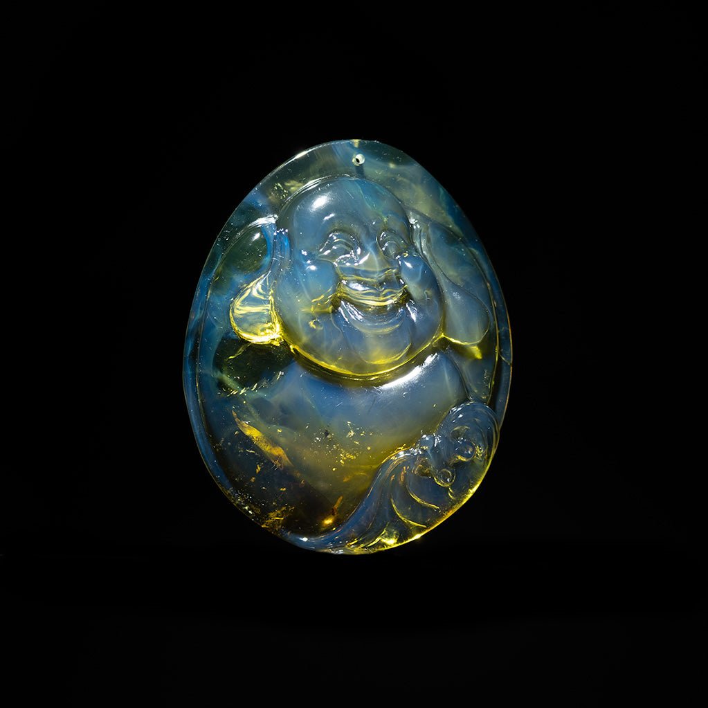 Blue amber pendant BUDDH Aon a red cord against a black background