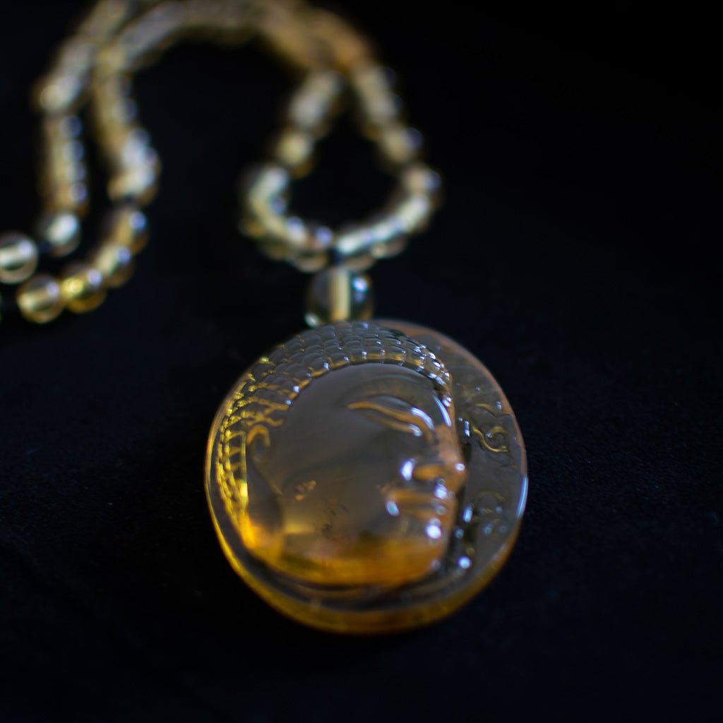 Necklace with a round pendant featuring an engraved face on a black background