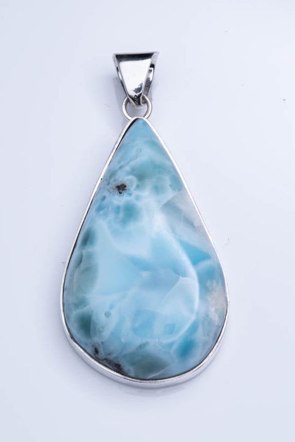 Teardrop-shaped larimar pendant on a white background