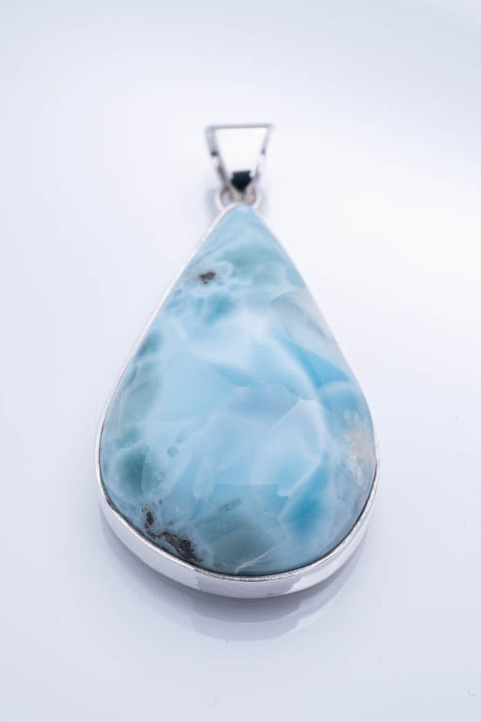 Teardrop-shaped larimar pendant on a white background