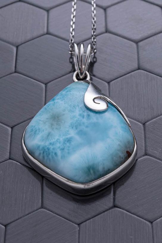 Turquoise pendant necklace on a hexagonal patterned surface